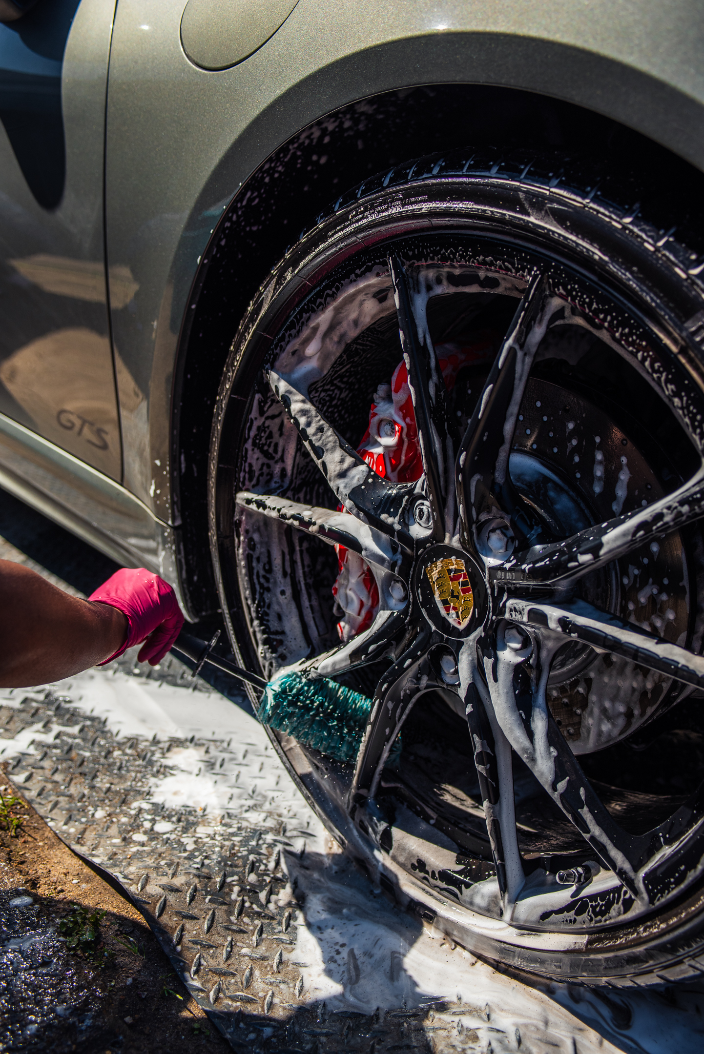 Porsche wheel being cleaned with foam